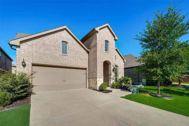 a view of house with garden and tall tress