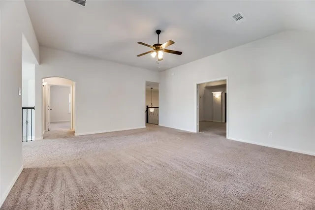 a view of an empty room and a ceiling fan window