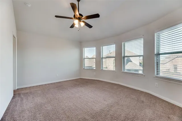 an empty room with windows and fan