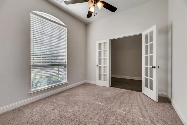 a view of empty room with window and ceiling fan