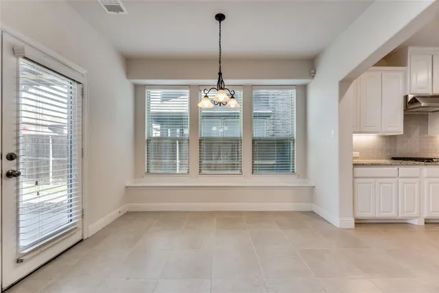 a view of an empty room with a fireplace and windows