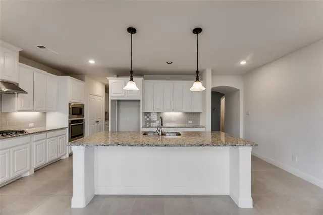 a view of a kitchen with a sink and stainless steel appliances
