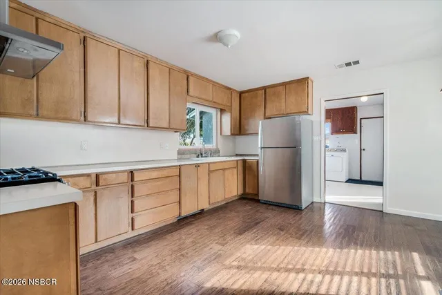 a kitchen with a refrigerator sink and cabinets