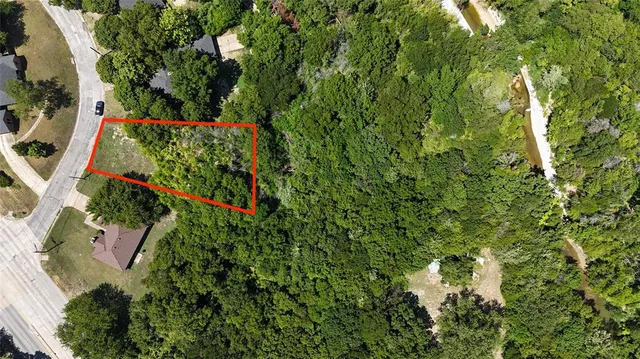 an aerial view of residential house with outdoor space and trees all around