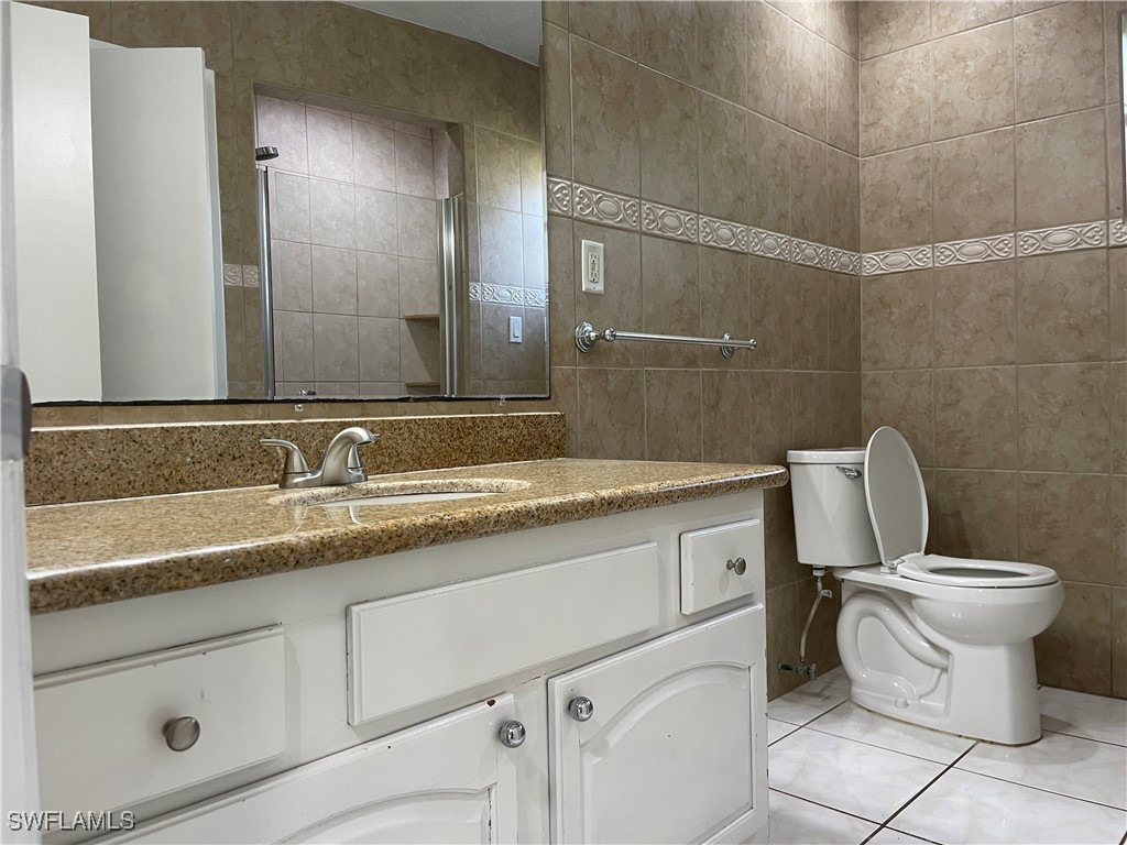 200 Ridgewood Avenue Clewiston, FL 33440 - Photo 36 of 50 a bathroom with a granite countertop toilet sink and mirror