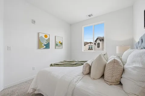 a bedroom with a bed and painting on the wall