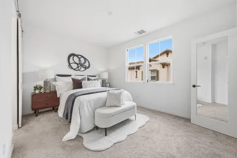 a bedroom with a bed and painting on the wall