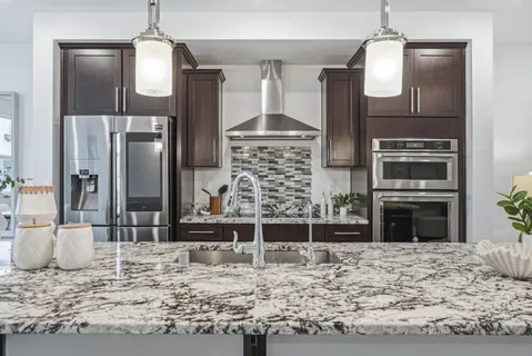 a kitchen with kitchen island granite countertop a refrigerator stove and oven
