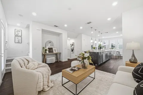 a living room with furniture and view of kitchen