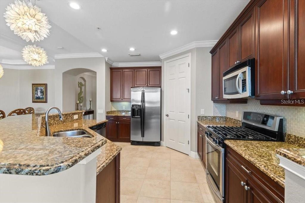 1143 Riverscape Street, Unit A Bradenton, FL 34208 - Photo 12 of 53 a kitchen with granite countertop stainless steel appliances and wooden cabinets