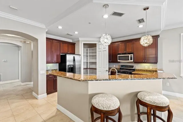 a kitchen with stainless steel appliances granite countertop a refrigerator a stove a sink a oven with a dining table and chairs