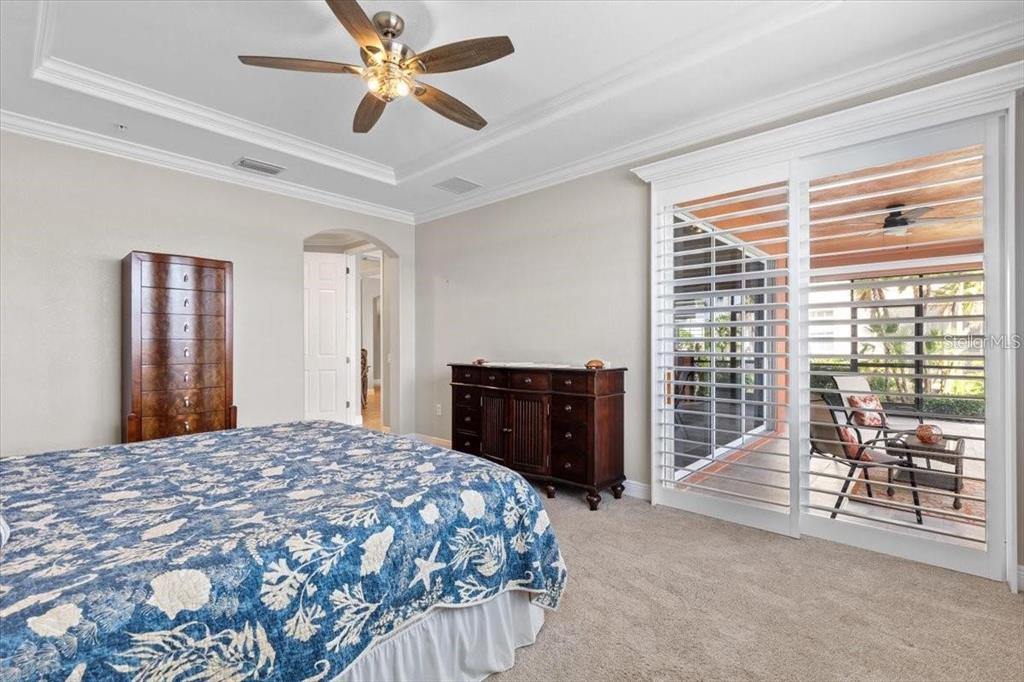 1143 Riverscape Street, Unit A Bradenton, FL 34208 - Photo 23 of 53 a bedroom with a balcony a bed and a chandelier