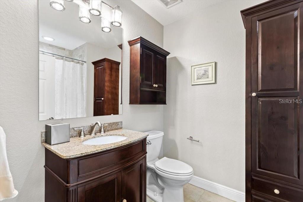 1143 Riverscape Street, Unit A Bradenton, FL 34208 - Photo 37 of 53 a bathroom with a granite countertop sink toilet and mirror