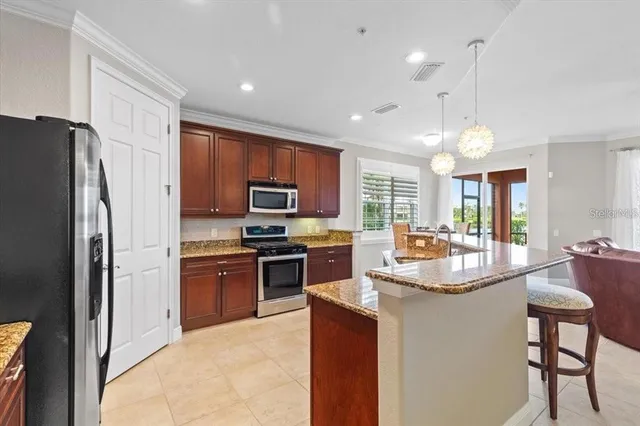 a kitchen with stainless steel appliances granite countertop a sink refrigerator and microwave