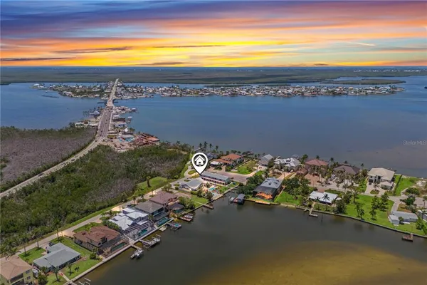 an aerial view of a house with outdoor space and a lake view in back
