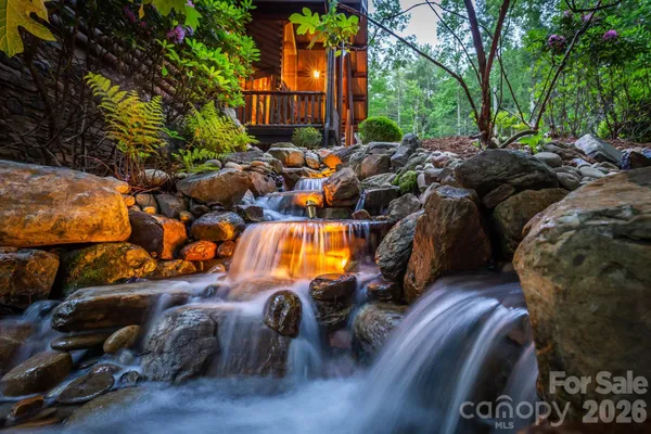 a view of a house with backyard water fountain and sitting area