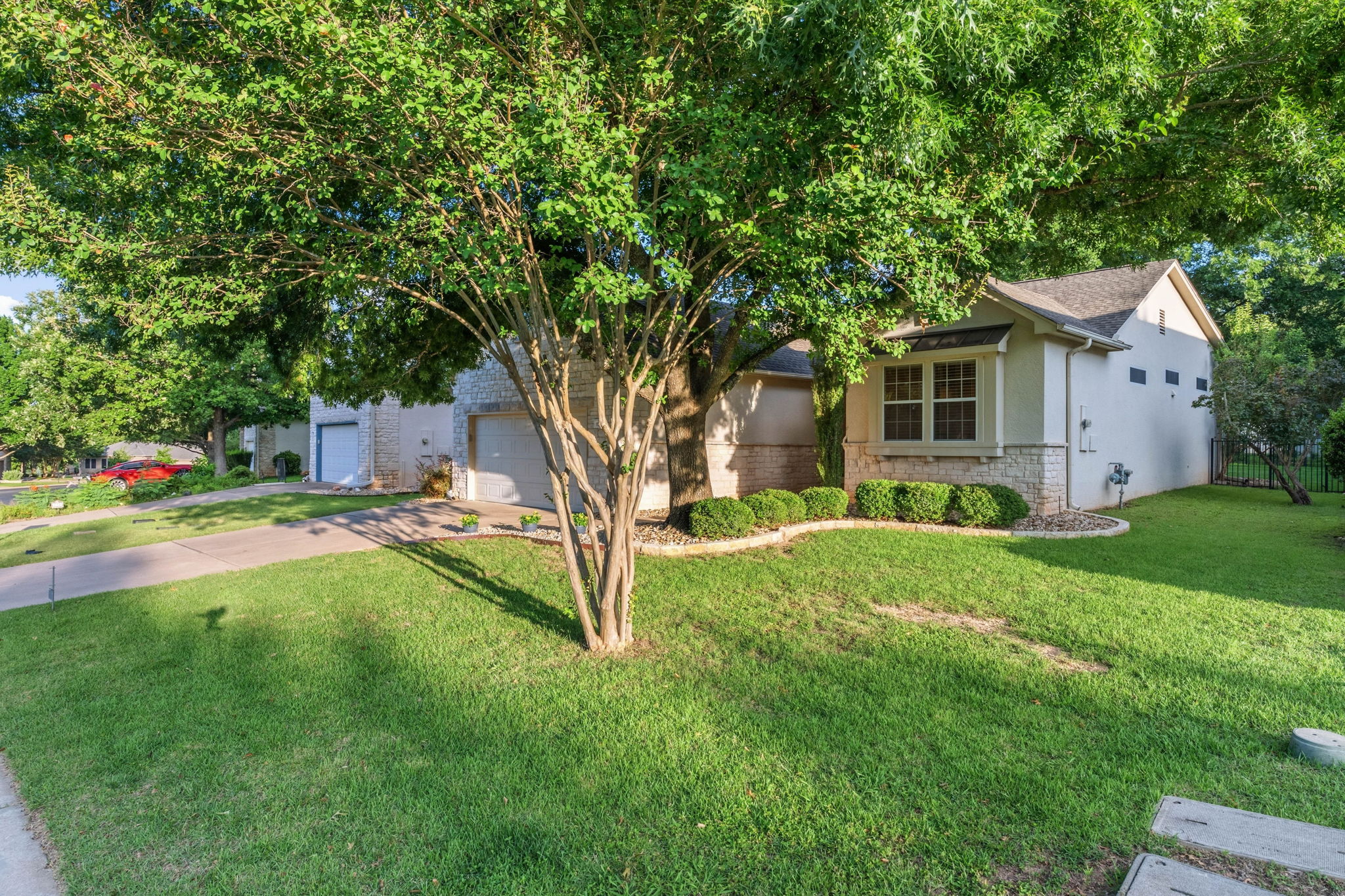 137 Trail Rider Way Georgetown, TX 78633 - Photo 26 of 29 Mature trees frame this inviting residence, showcasing its well-tended landscaping and ample driveway space.