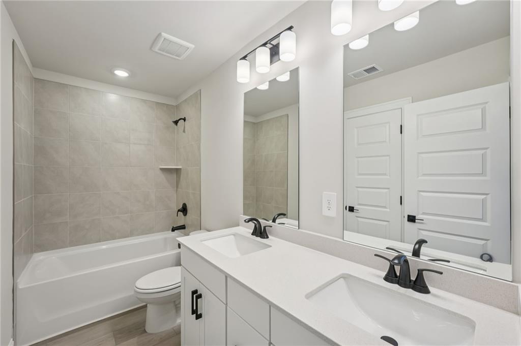 6440 Pinin Place Cumming, GA 30041 - Photo 37 of 52 a bathroom with a sink a toilet a tub and a mirror