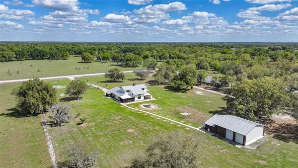 an aerial view of a house with swimming pool and a yard