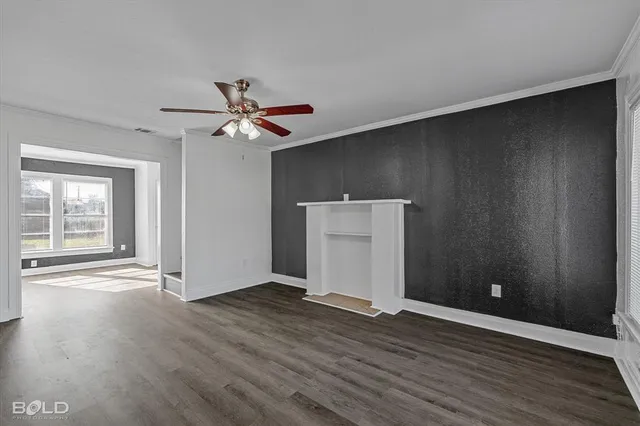 a view of an empty room with wooden floor