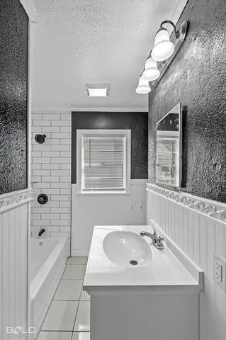 a bathroom with a sink a toilet a mirror and bathtub