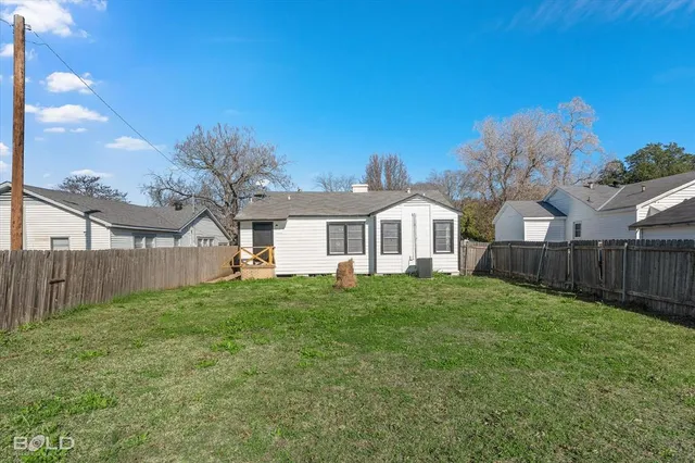 a view of a yard in front of a house with large trees