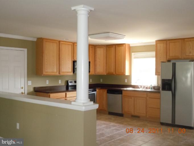 9065 Rixeyville Road Rixeyville, VA 22737 - Photo 7 of 12 a kitchen with stainless steel appliances granite countertop a sink a stove and a refrigerator