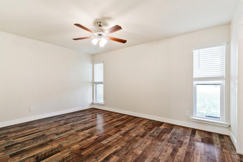 909 North Dove Road Grapevine, TX 76051 - Photo 21 of 30 2nd bedroom featuring wood-finish flooring, light-colored walls, and a ceiling fan with integrated lighting