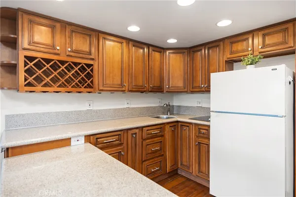 a kitchen with stainless steel appliances granite countertop a refrigerator and a sink