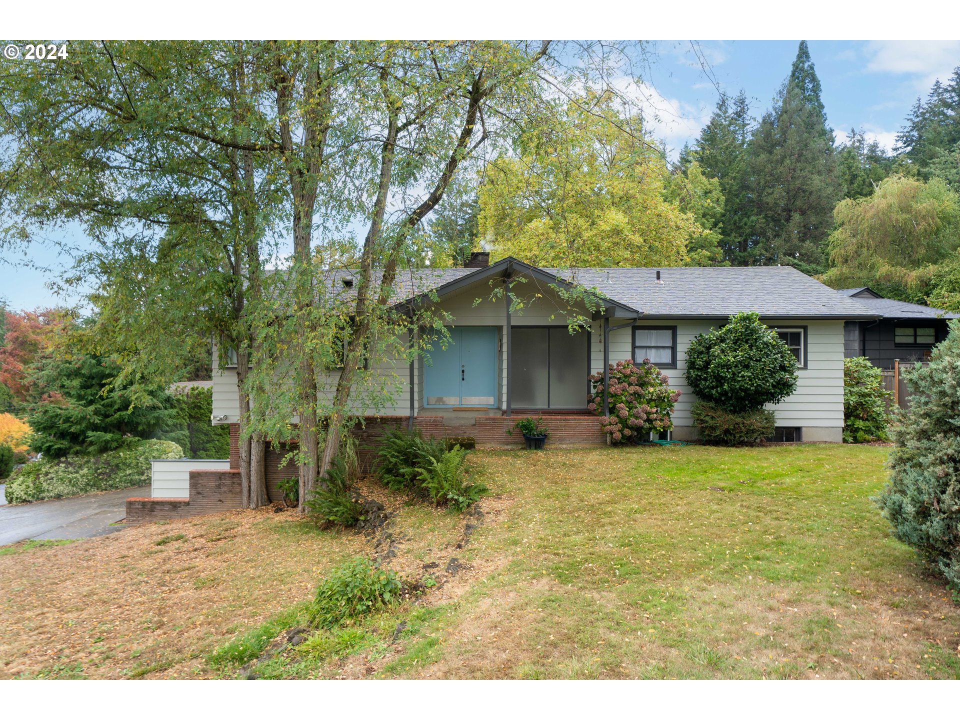 a view of a house with garden and trees