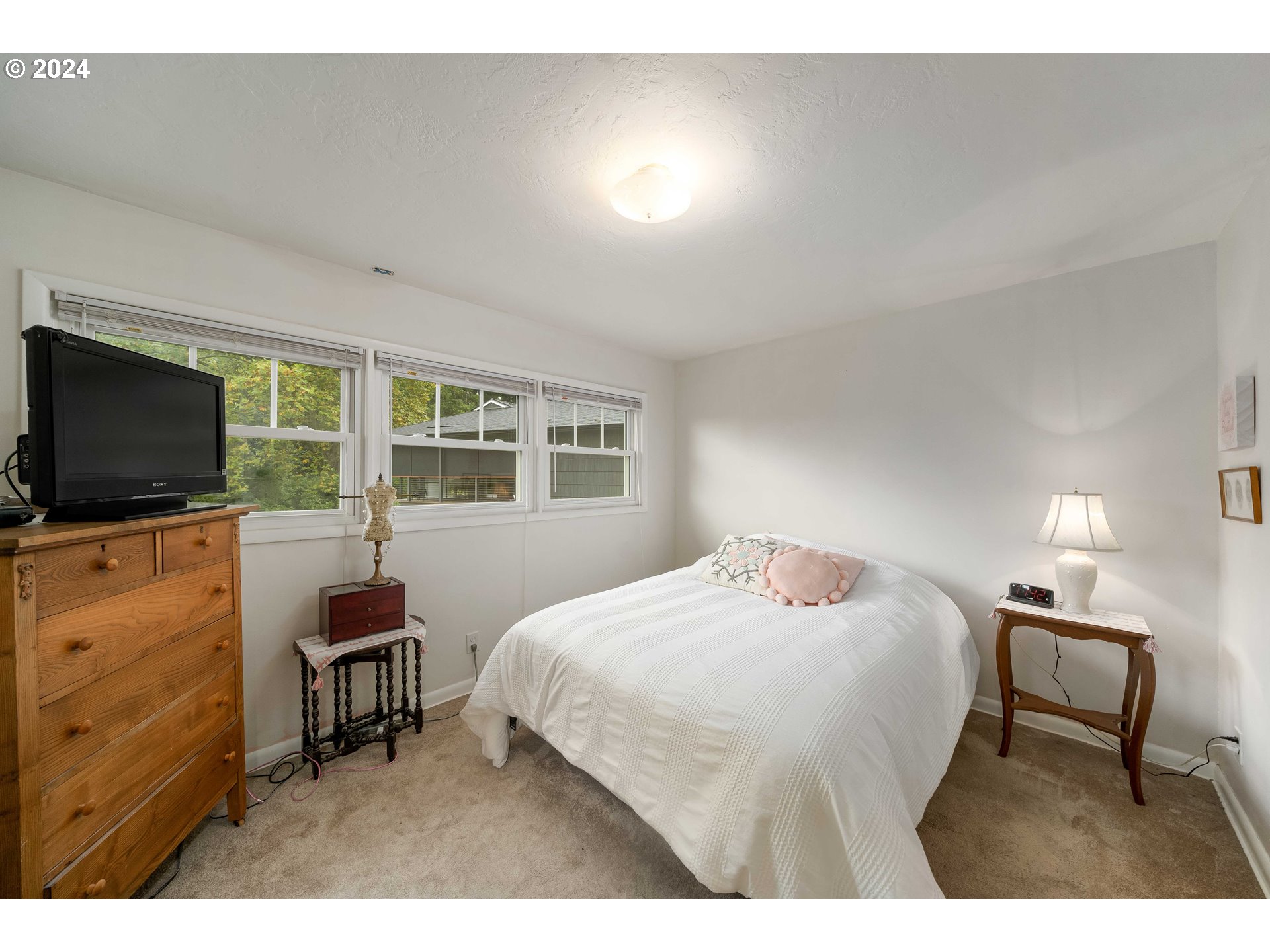 4425 Southwest Dosch Road Portland, OR 97239 - Photo 24 of 40 a bedroom with a bed and a flat tv screen on dresser