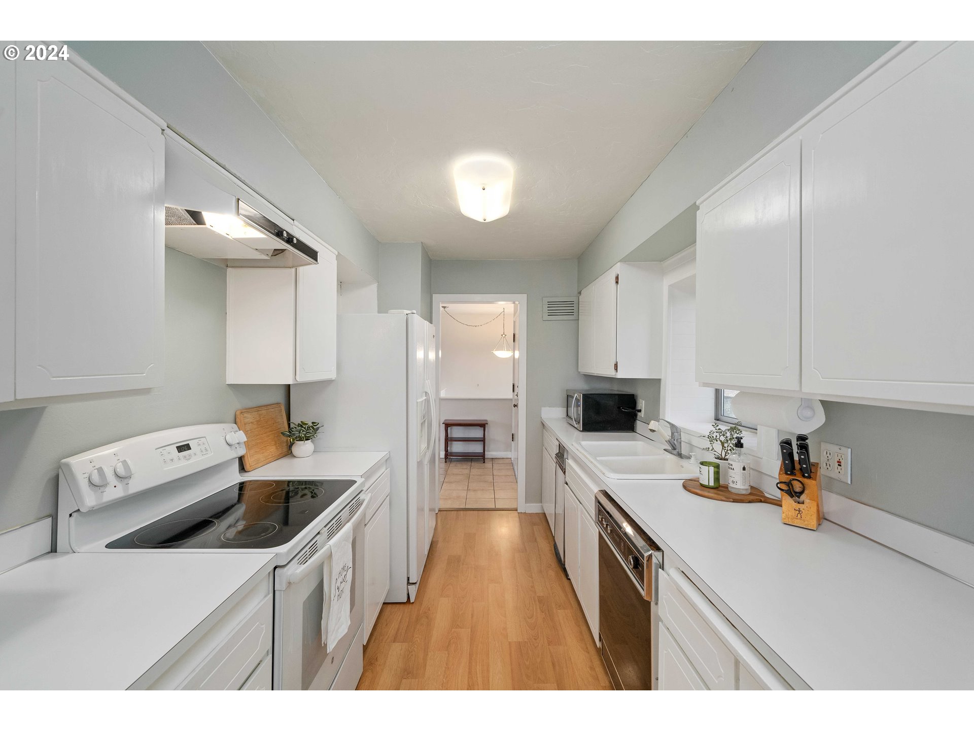 4425 Southwest Dosch Road Portland, OR 97239 - Photo 8 of 40 a kitchen that has a lot of cabinets a sink and a stove in it