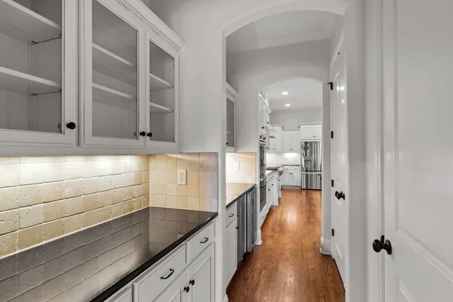 a view of a hallway with wooden floor and a chandelier