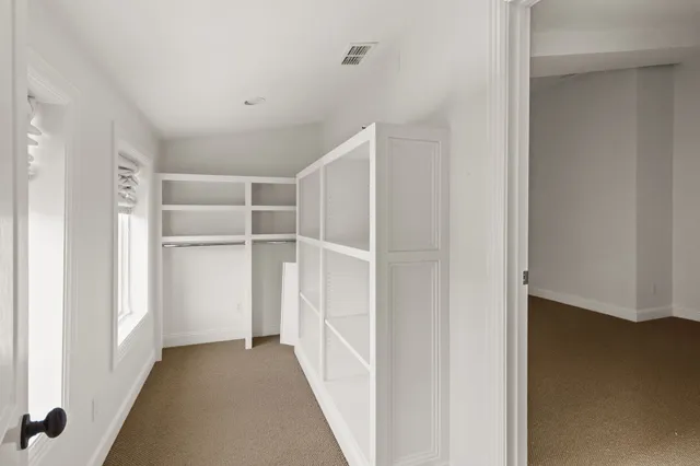 a view of a hallway with wooden floor and stairs