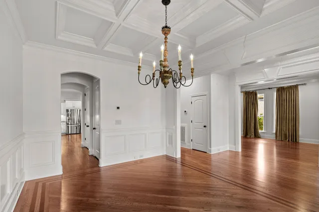 a view of a big room with wooden floor a chandelier and entryway