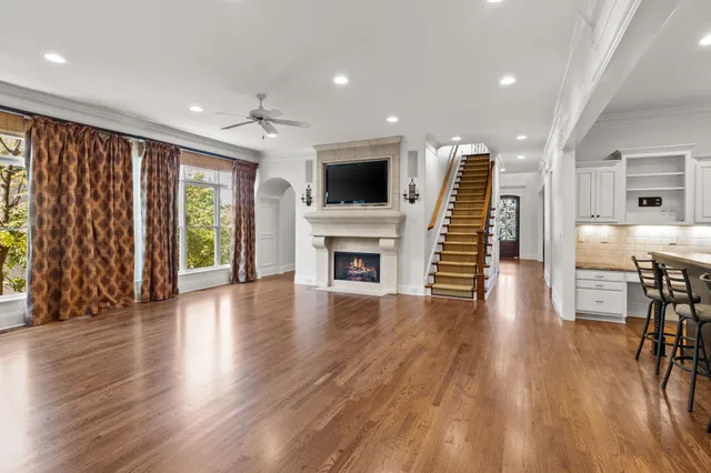 an empty room with fireplace wooden floor and windows