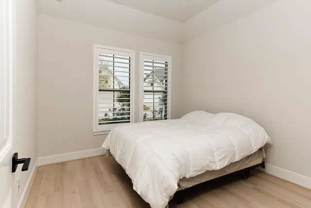 a large bed sitting in a bedroom next to a window