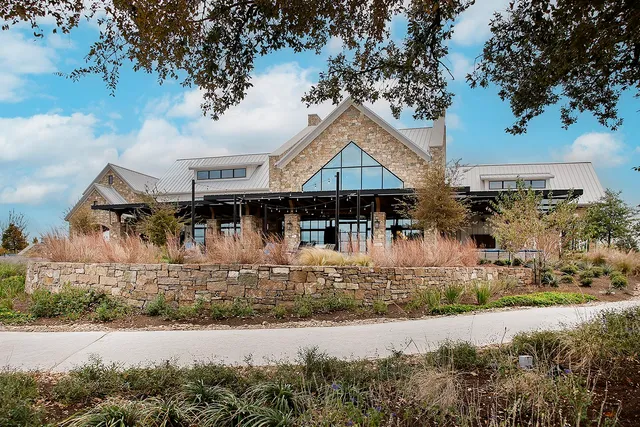 an aerial view of a house with lake swimming pool and a yard