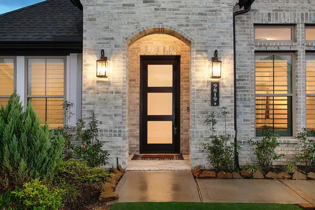a view of a brick house with potted plants