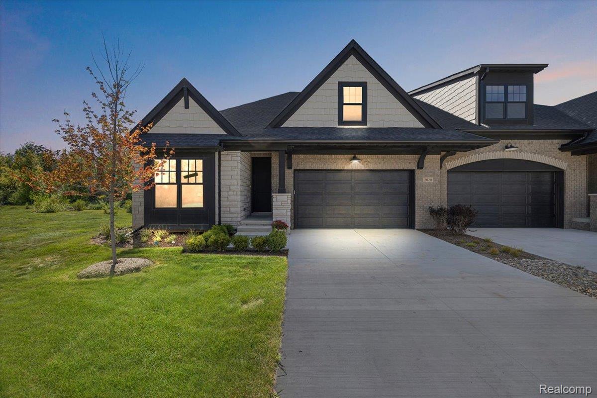 2032 Breckenridge Court, Unit 9 Rochester, MI 48309 - Photo 1 of 39 View of front of property with driveway, a front yard, a garage, and stone siding