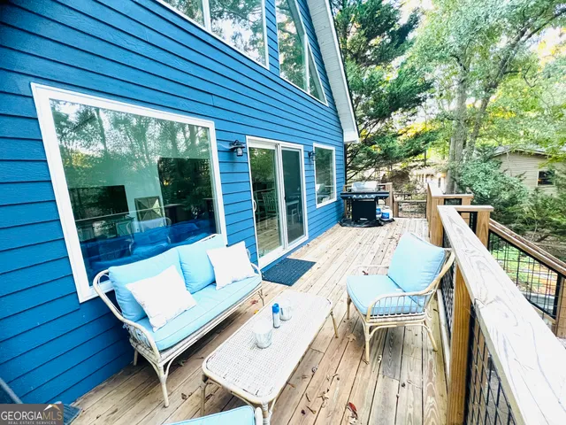 a view of a patio with table and chairs with wooden floor and fence