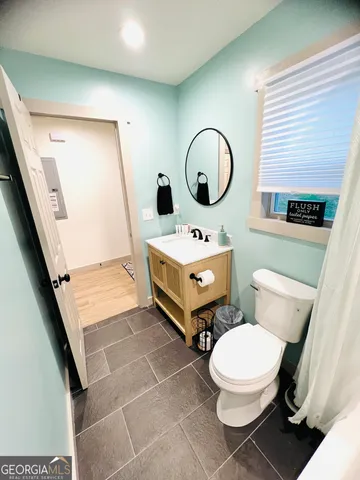 a bathroom with a toilet sink and mirror