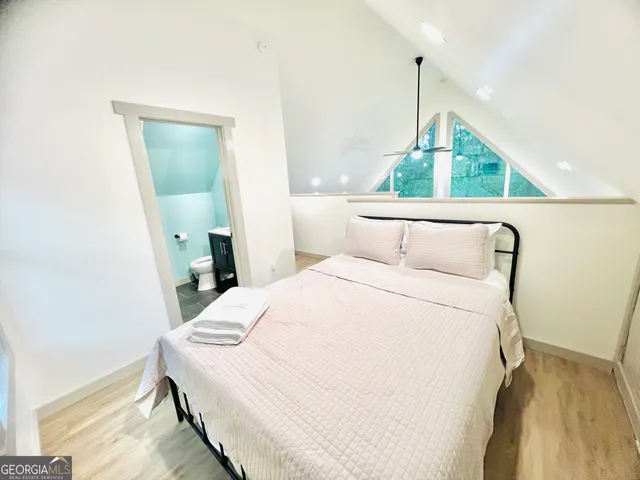 a bedroom with a bed a mirror and a window