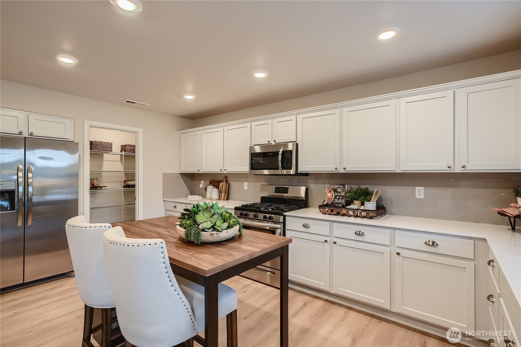 1212 15th Avenue Sultan, WA 98294 - Photo 3 of 19 a kitchen with white cabinets and stainless steel appliances