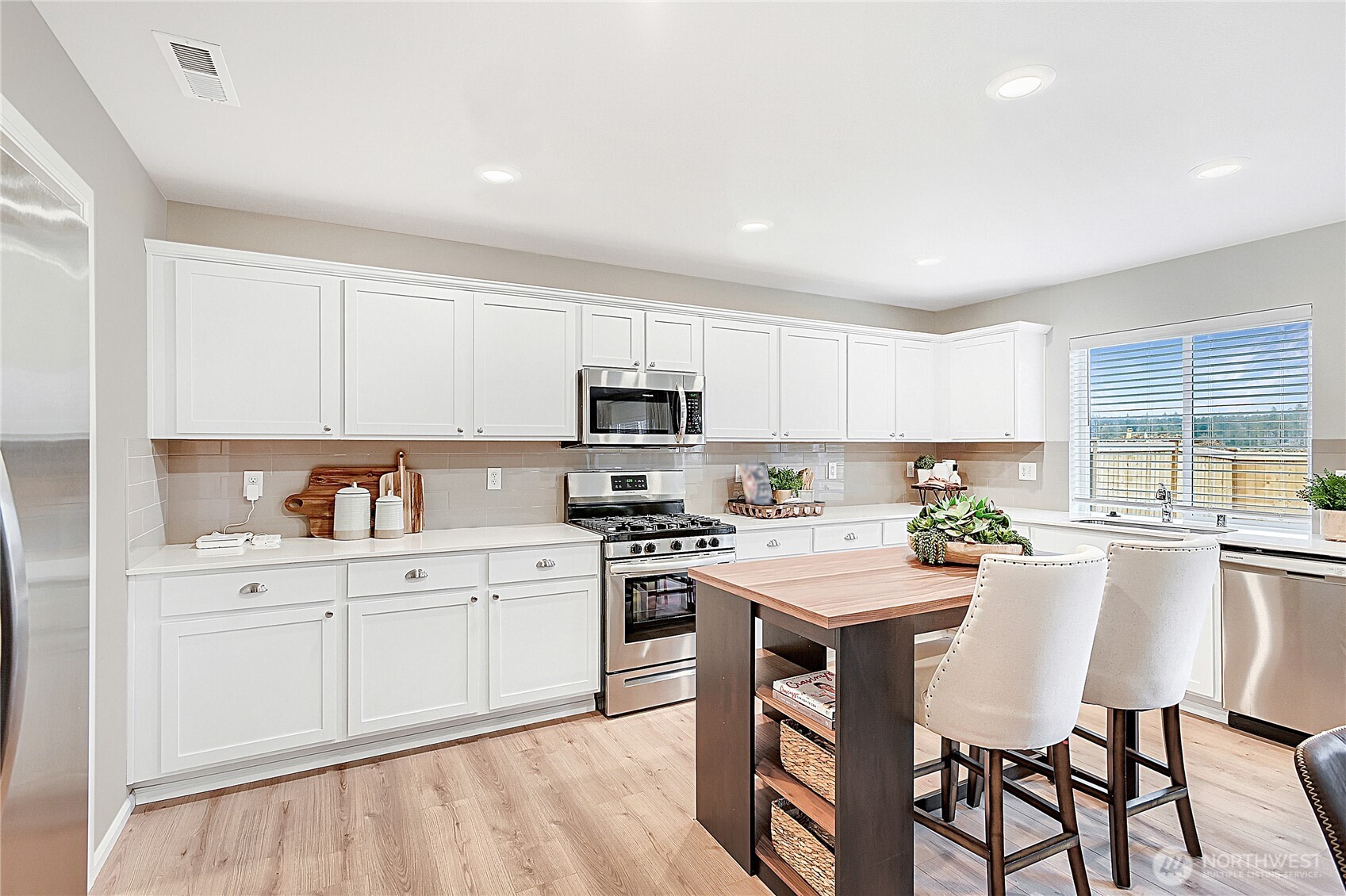 1212 15th Avenue Sultan, WA 98294 - Photo 5 of 19 a kitchen with white cabinets stove and chairs