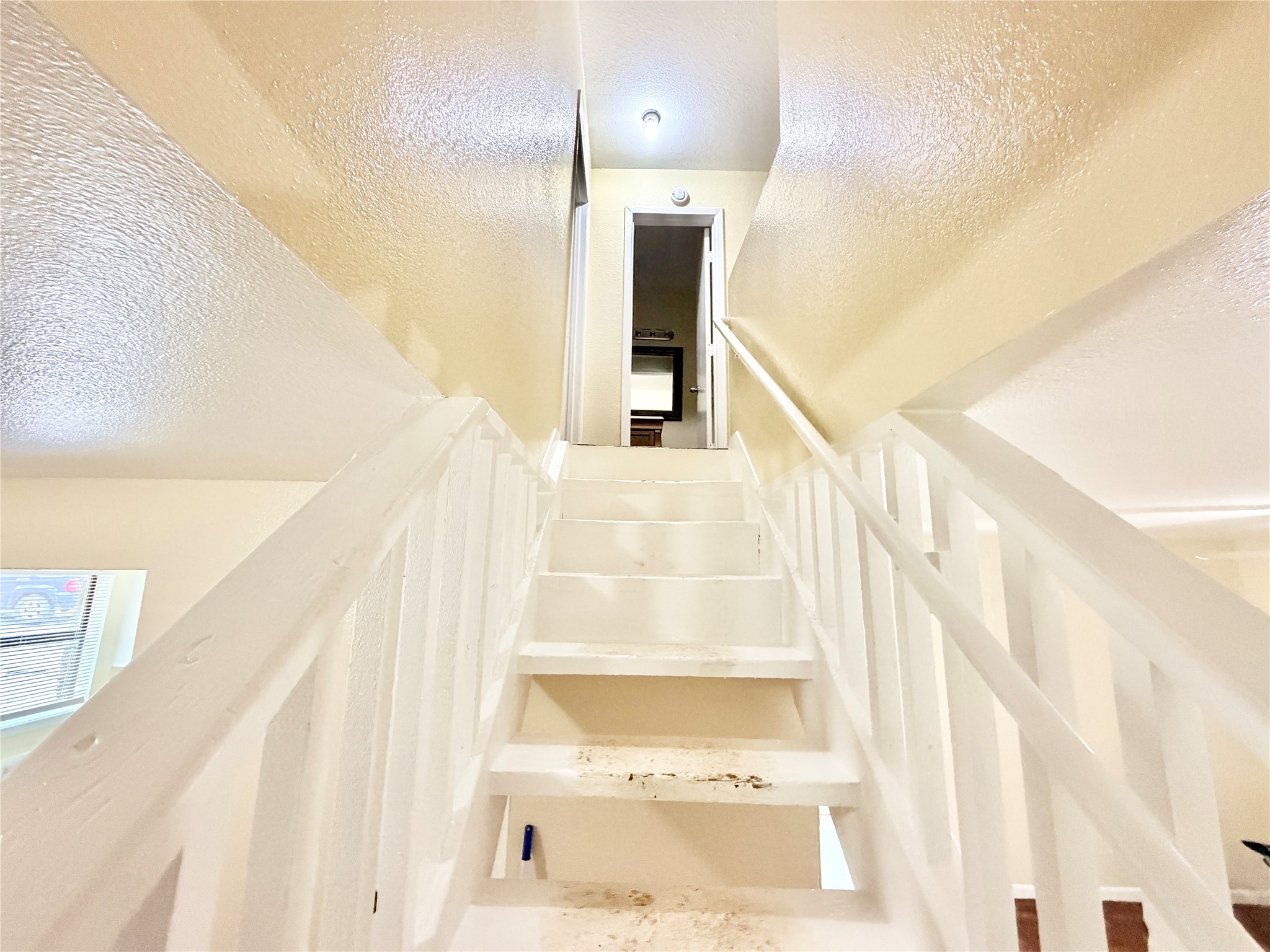 6257 Manor Road, Unit B Austin, TX 78723 - Photo 17 of 38 Interior staircase featuring white painted treads and risers, with matching white painted handrails and spindles