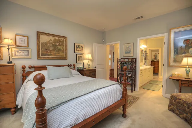 a spacious bedroom with a bed and wooden floor