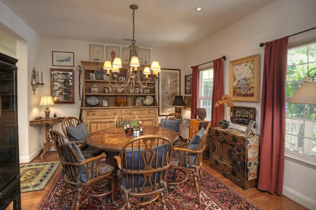 a kitchen with stainless steel appliances granite countertop a stove a refrigerator a sink dishwasher a dining table and chairs with wooden floor