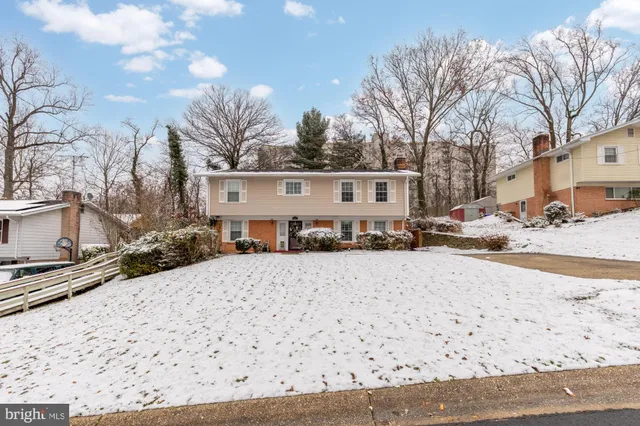 a front view of a house with a yard covered in snow