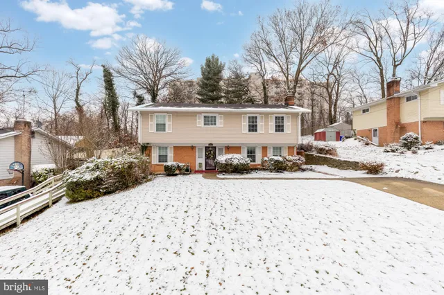a front view of a house with a yard covered in snow